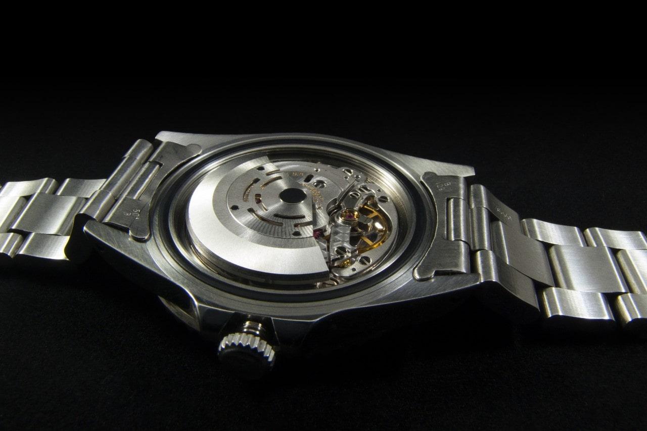 A close-up of the back of a luxury watch, prepared for servicing.