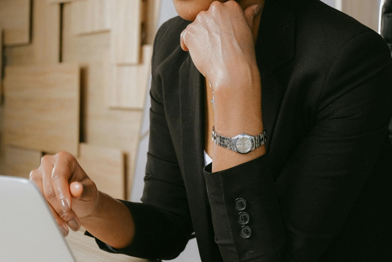 a woman in black wearing a silver watch with a small watch case